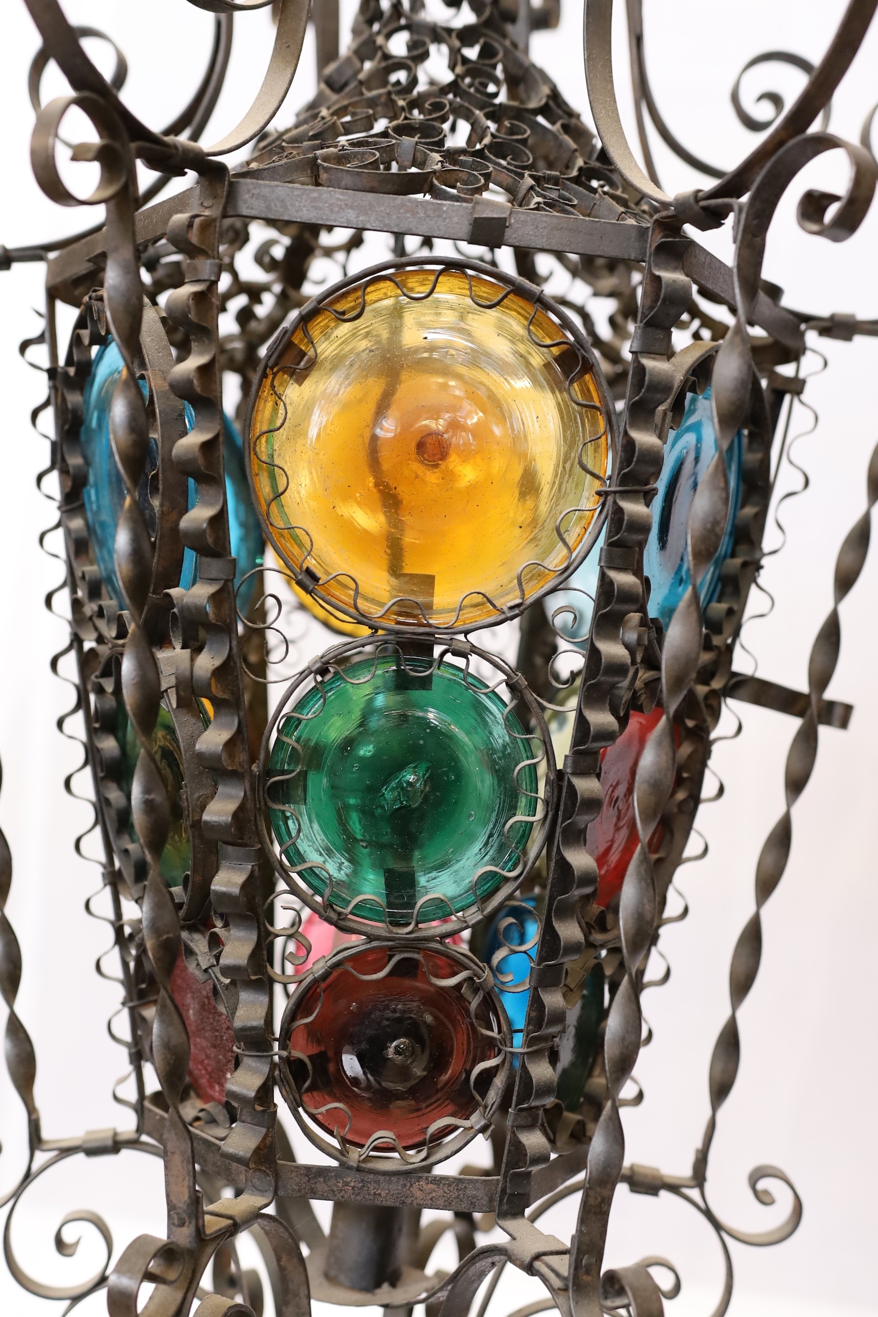 An early 20th century French wrought iron and coloured glass lantern of tapering hexagonal form, height 80cm. width 50cm